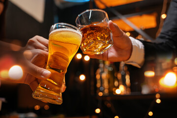 food and drink male friends are happy drinking beer and clinking glasses at a bar or pub.