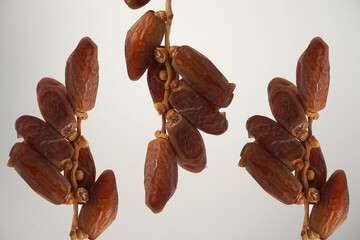 three bunches of dates hanging with white background isolated