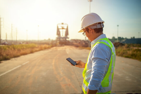 Men Engineer using mobile phone and holding tablet for inspecting and working at construction site