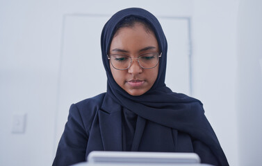 Muslim, tablet working and hijab of a serious woman employee from Dubai writing code. Islam, web...