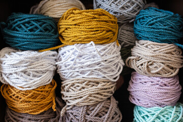 Multicolored cotton balls of yarn and ropes for macrame close up
