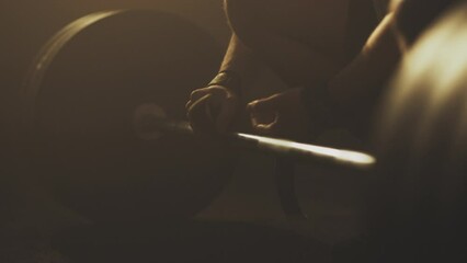 Slow-motion shot of an athlete wrapping straps around barbell getting ready for deadlifting, close up shot - Powered by Adobe
