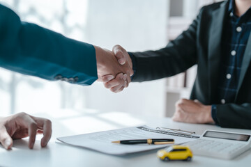 Shaking hands after succesful sign a contract and pay for money, A car dealer or sales manager...