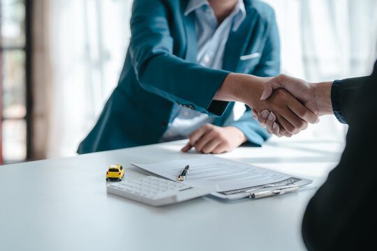 Shaking Hands After Succesful Sign A Contract And Pay For Money, A Car Dealer Or Sales Manager Offers To Sell A Car And Explains The Terms Of Signing A Car And Insurance Contract.