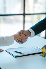 Shaking hands after sign a contract, realtor suggestion a new house model assisting client to sign...