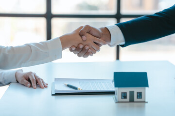 Shaking hands after sign a contract, realtor suggestion a new house model assisting client to sign contract agreement with insurance to happy living building, concerning mortgage loan offer