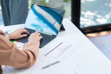 Cropped shot of beautiful  woman typing emails on laptop computer while sitting at home, selective focus in hand