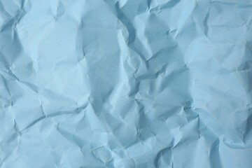 Sheet of crumpled light blue paper as background, top view