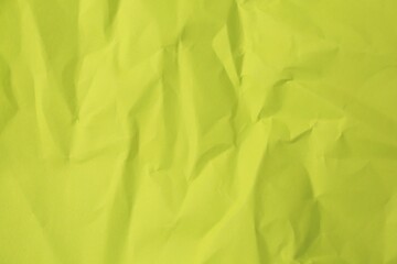 Fototapeta premium Sheet of crumpled light green paper as background, top view