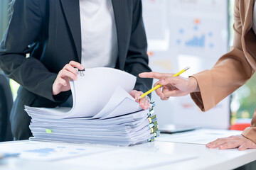 Business documents concept: Businesswoman hands working in Stacks of paper files for searching and...