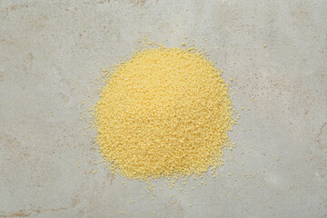 Heap of raw couscous on light table, top view