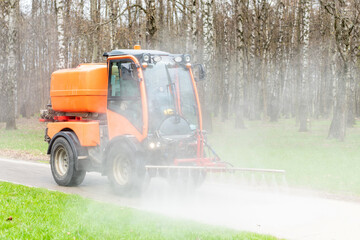 Road cleaning machine. a small car washes the park from dirt and dust