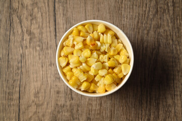 A cup of hot boiled corn on rustic wooden table. Healthy organic nutrition and vegetarian food concept