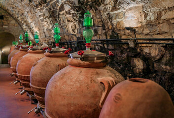 Chianti wine from Sangiovese grapes aging in terracotta clay amphora at a vineyard cellar in the...