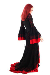 portrait of beautiful red haired woman wearing long black fantasy vampire costume gown, isolated pose on  studio background.