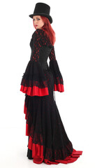 portrait of beautiful red haired woman wearing long black fantasy vampire costume gown, isolated pose on  studio background.