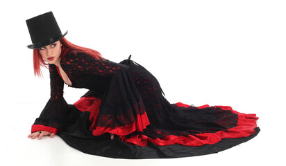 portrait of beautiful red haired woman wearing long black fantasy vampire costume gown, isolated...