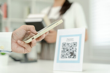 Customer use smartphones to scan QR codes to pay in-store with digital payments without cash....