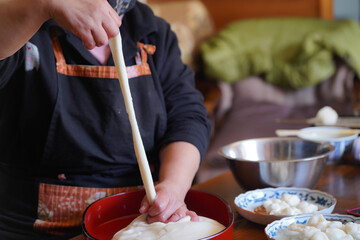 つきたてのお餅に食材を絡める女性