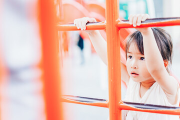 公園の遊具で遊ぶ小さな女の子