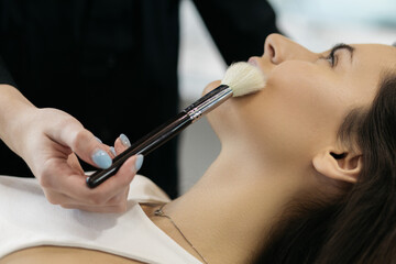 A girl in a beauty salon. The girl is applying make-up.