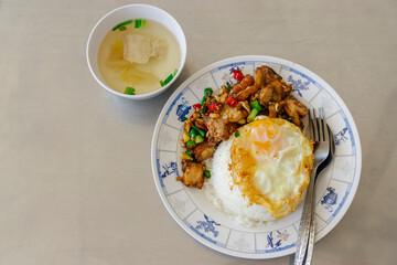 Thai street food , spicy crispy pork Krapao rice with fired egg on metal background