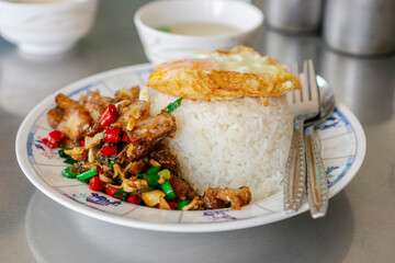 Thai street food , spicy crispy pork Krapao rice with fired egg on metal background