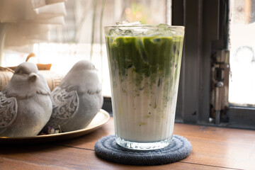 Cold iced matcha green tea latte on table in cafe. Selected focus.