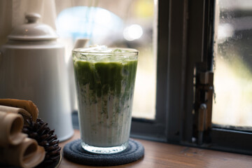 Cold iced matcha green tea latte on table in cafe. Selected focus.