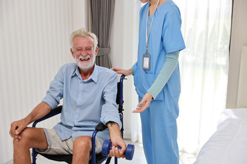 Obraz premium Happy caregiver helping senior elderly man lifting dumbbell and excercise with wheelchair at home or retirement house. Asian smiling nurse taking good help care and support of elder patient at house.