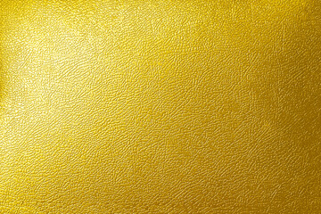 Gold wall texture background. Yellow shiny gold sheet surface with light reflection, vibrant golden luxury wallpaper
