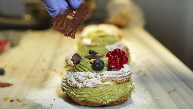 Paris Brest, a classic French dessert consist of large baked ring of choux pastry, filled with soft Pistachio and hazelnut cream topped with roasted Pistachio and hazelnut.