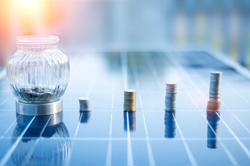 silver coin on solar panel Cells help store solar energy.Then used to produce electricity for homes and buildings to use, reducing costs and preserving the environment.that helps reduce global warming