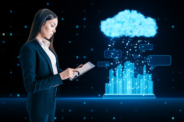 Attractive young european businesswoman using tablet with glowing urban cloud and city communication hologram on blurry blue tech background. Smart city and IOT concept.