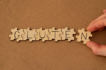 A woman assembles a word out of wooden puzzles that say gluten.