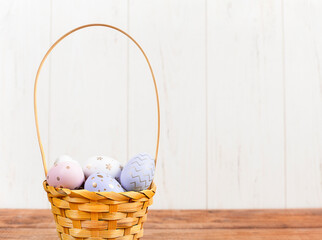 basket with colorful easter eggs on a wooden table