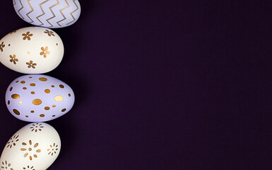 white and purple Easter eggs on a blue background. View from above