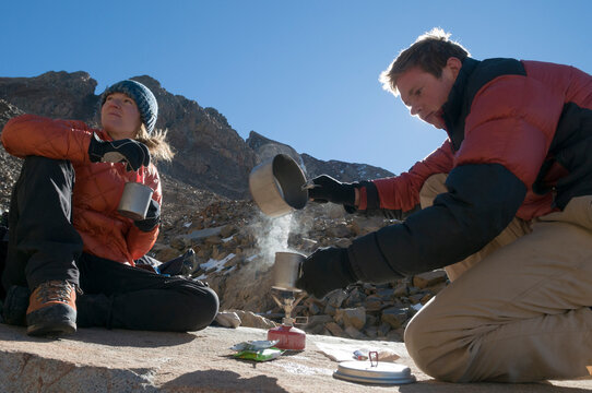 A man and a woman boiling water on a campstove above treeline near Telluride, Colorado.