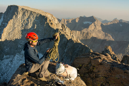 Man coiling rope on summit of Mount Mendel