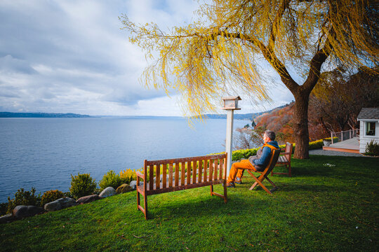A man is sitting in s chair near Puget Sound