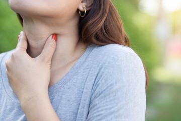 Beautiful young woman touching her sick neck with hands she has neck pain
 Sore throat Difficulty swallowing