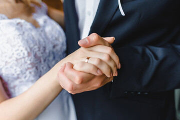 groom holding bride's hand on wedding day