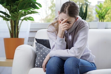 Woman at home suffers from severe headache, migraine or depression and malaise