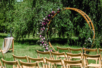 Wedding ceremony. Very beautiful and stylish wedding arch, decorated with various fresh flowers, standing in the garden. Wedding day. Fresh flowers decorations, Peony weddng.