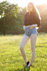 Pretty young woman smiling friendly on a sunny summer day outdoors