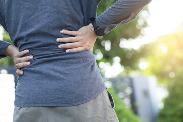 The man is holding his back with both hands. Have back pain. Back pain.