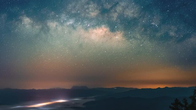 Colorful night sky with moving Milky Way above the northern landscape of Chiang Mai, Thailand with the famous Doi Luang Chiang Dao seen in the distant, view from Doi Dum in Amphur Vienna Hang