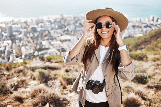 Portrait, travel and woman photographer hiking in nature, happy and relax on adventure on cityscape. Face, photography and girl student backpacking, sightseeing and on a solo trip in South Africa