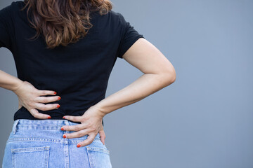 Beautiful woman holding her back with two hands She has back pain. Back pain.