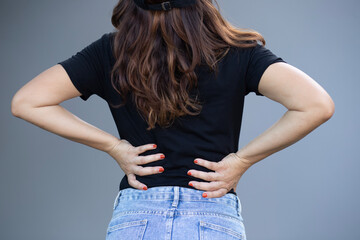 Beautiful woman holding her back with two hands She has back pain. Back pain.